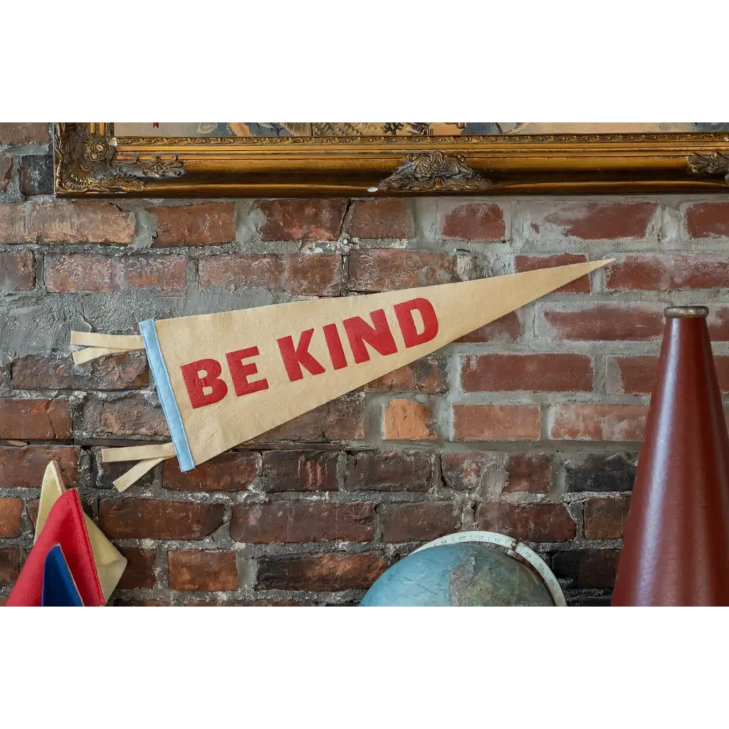 Tan Be Kind Pennant Flag with red lettering, perfect for stylish womens clothes and polished prints
