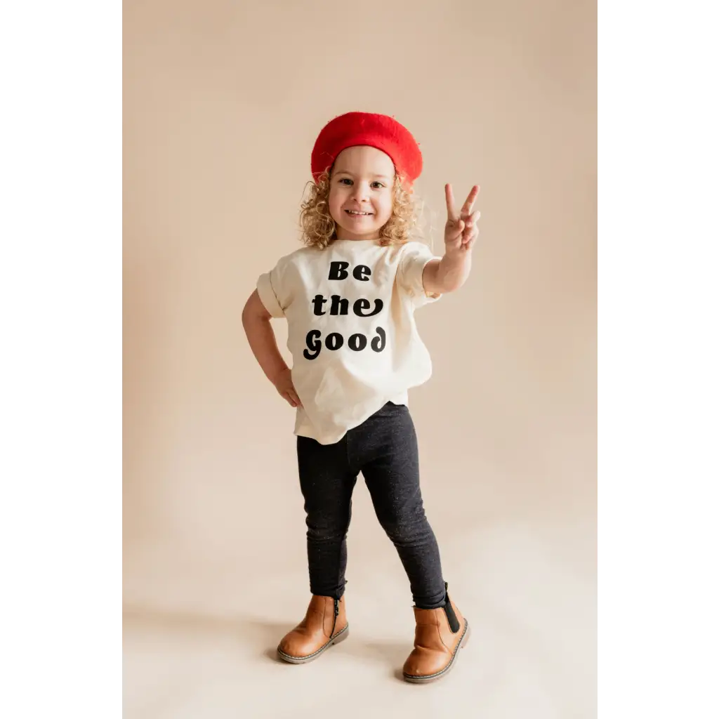 Child in a red beret rocking a Be the Good organic cotton graphic t-shirt by Polished Prints