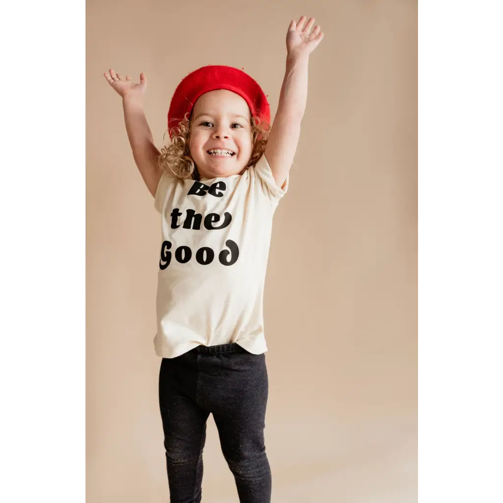 Joyful figure in red beret and Be the Good Organic Cotton Graphic T-shirt by Polished Prints