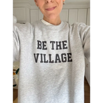 Heather gray Be the Village adult unisex pullover with bold black text