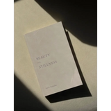 White book titled Beauty Stillness, part of polished prints collection for stylish moms