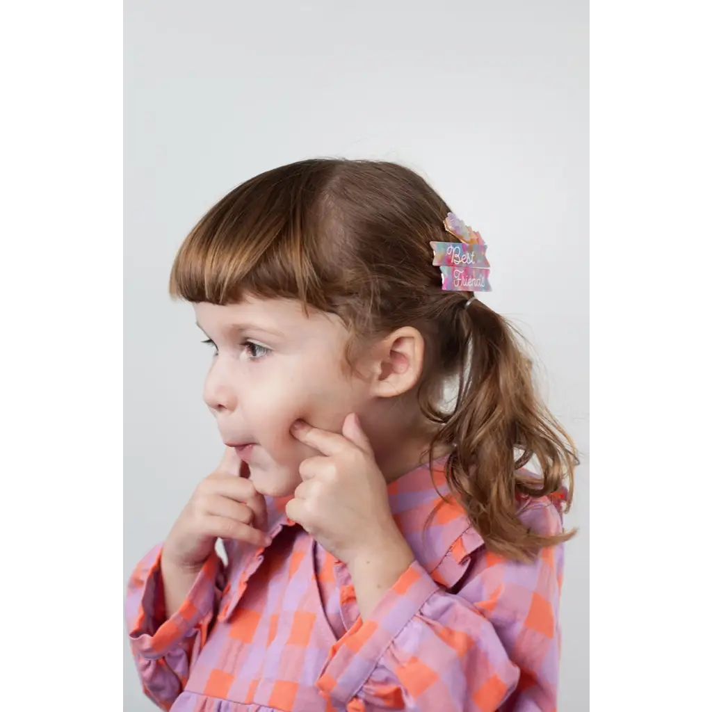 Child in a colorful dress wearing Best Friends Hair Clips with pink hearts