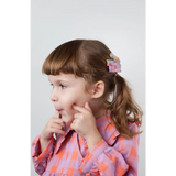 Child in a colorful dress wearing Best Friends Hair Clips with pink hearts