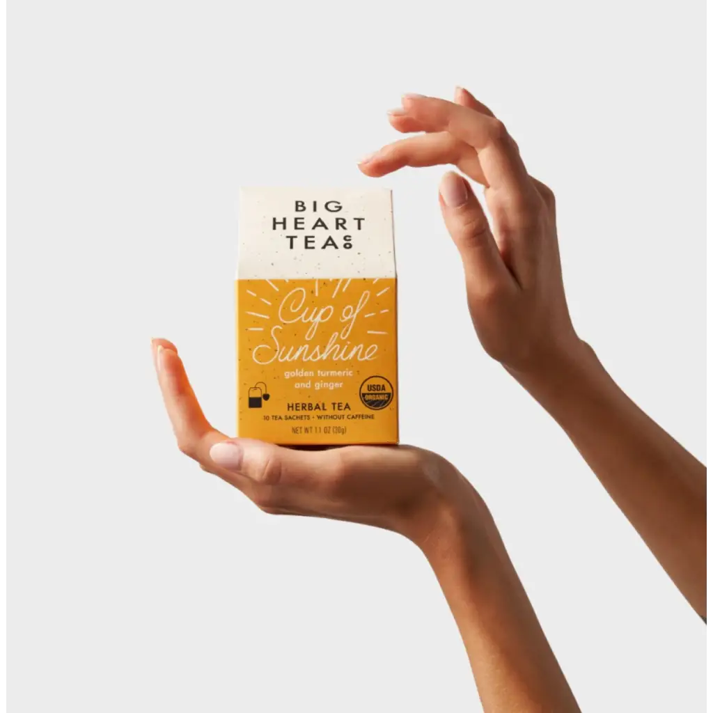 Big Heart Tea Co. Cup of Sunshine herbal tea box showcasing stylish womens clothes and polished prints