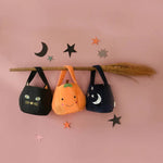 Halloween-themed tote bags hanging from a broomstick, perfect for your Black Cat Bucket Bag look