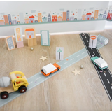 Toy road setup with miniature vehicles and buildings using Black Play Road Tape