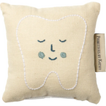 Cute smiling tooth fairy pillow in soft beige with blue eyes and white stitching