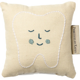 Cute smiling tooth fairy pillow in soft beige with blue eyes and white stitching