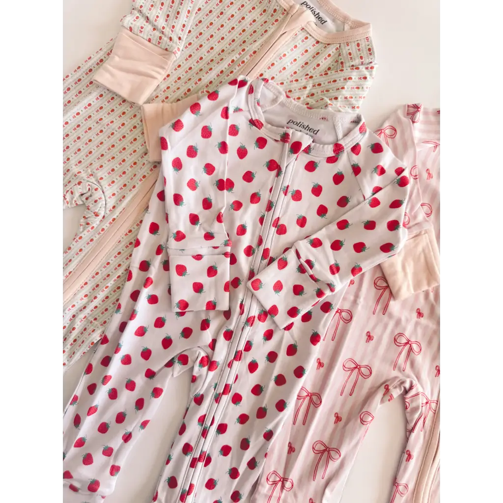 Polished white bamboo baby sleeper onesie with red strawberries