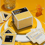 White cube trivia game box for Trivial Drinking with black text and yellow spirals