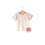 Cream-colored Bunny Hive Signature Ringer Tee with pink trim for a cute casual look