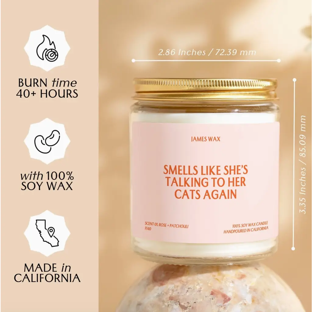 White soy wax candle in a jar with gold lid, featuring rose + patchouli scent and fun text