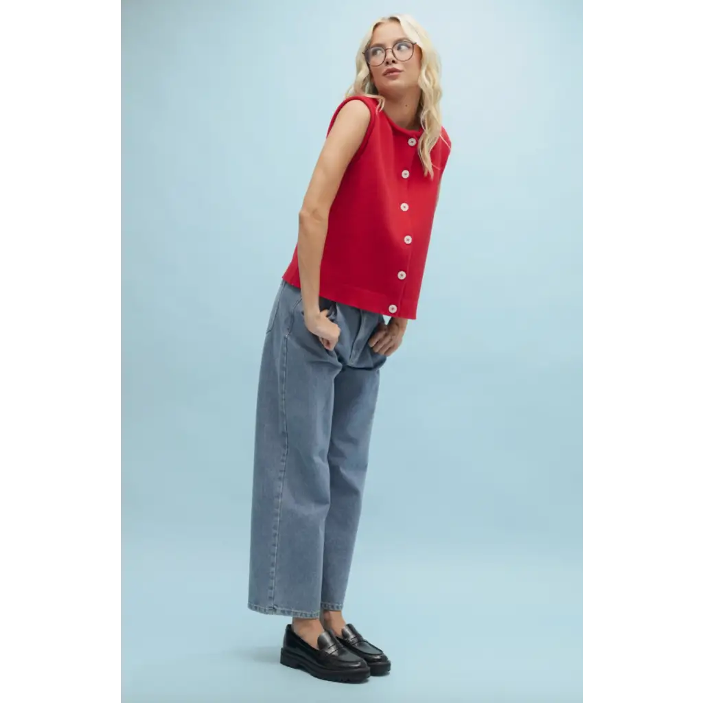 Woman in red button-up top and jeans showcasing stylish womens clothes for moms
