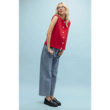 Woman in red button-up top and jeans showcasing stylish womens clothes for moms