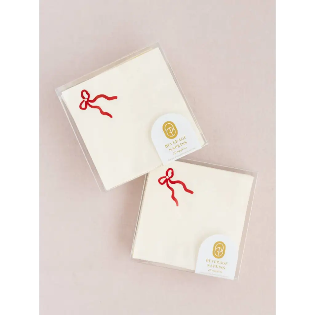 Two packages of white beverage napkins with red bow design for stylish events