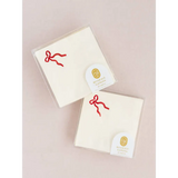 Two packages of white beverage napkins with red bow design for stylish events
