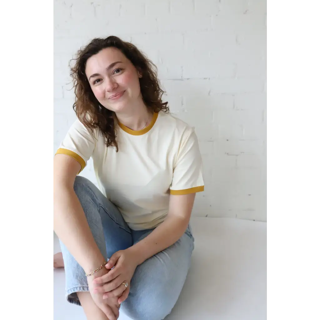 Woman in mustard classic women’s ringer tee made from organic cotton with polished prints