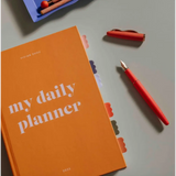 Orange daily planner with a red fountain pen showcasing Cloud Sticky Index Tabs and sticky index tabs