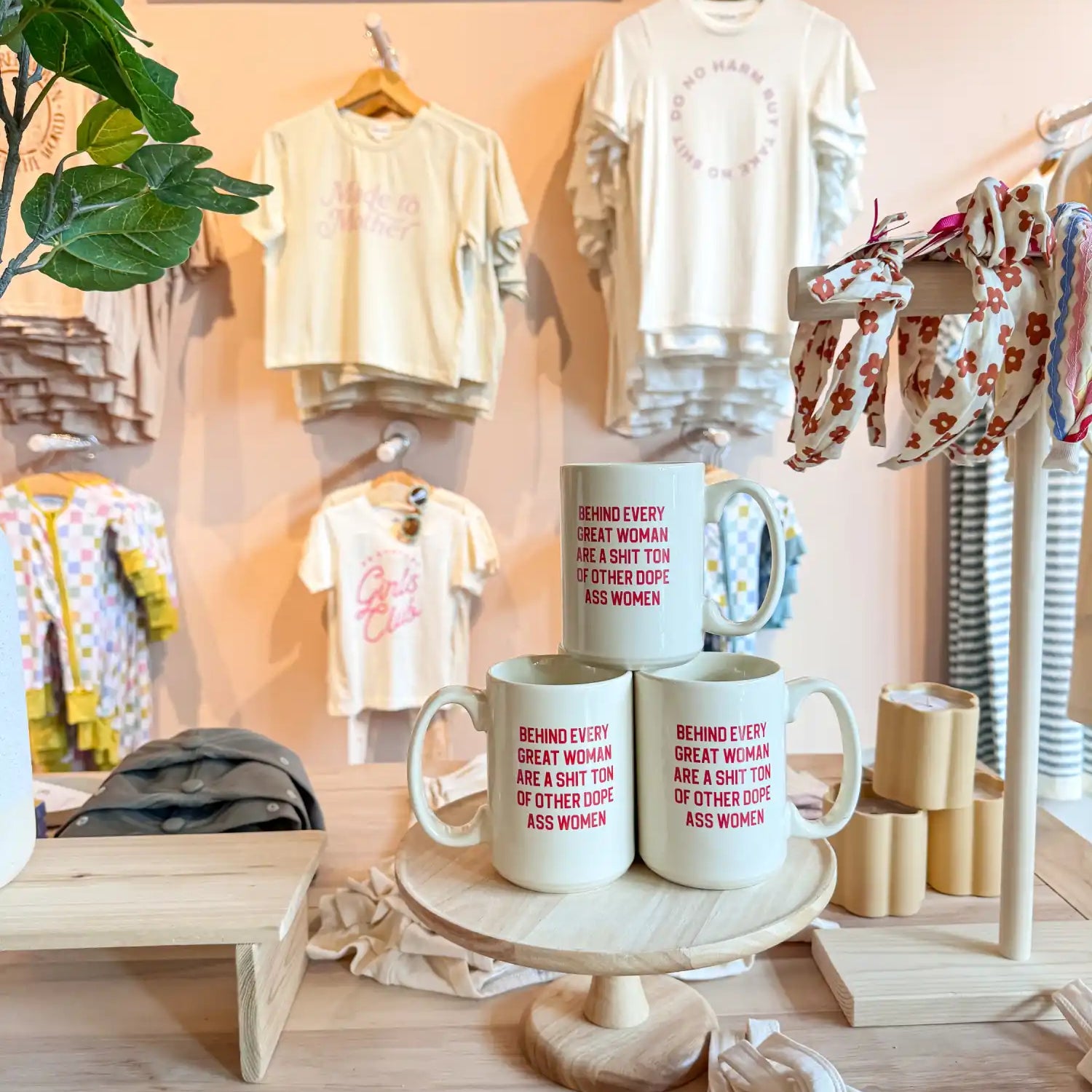 Coffee mugs displayed on a white pedestal stand.