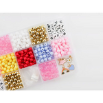Colorful beads and craft supplies in the Color My World Bracelet Craft Kit for stretchy bracelets