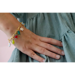 Gold-toned charm bracelet with colorful beads and daisy charms