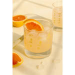 Glass of grapefruit juice with ice and a grapefruit slice in a Cowboy Cocktail Glass