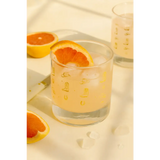 Glass of grapefruit juice with ice and a grapefruit slice in a Cowboy Cocktail Glass