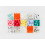 Colorful plastic beads in compartments for a fun bracelet craft kit