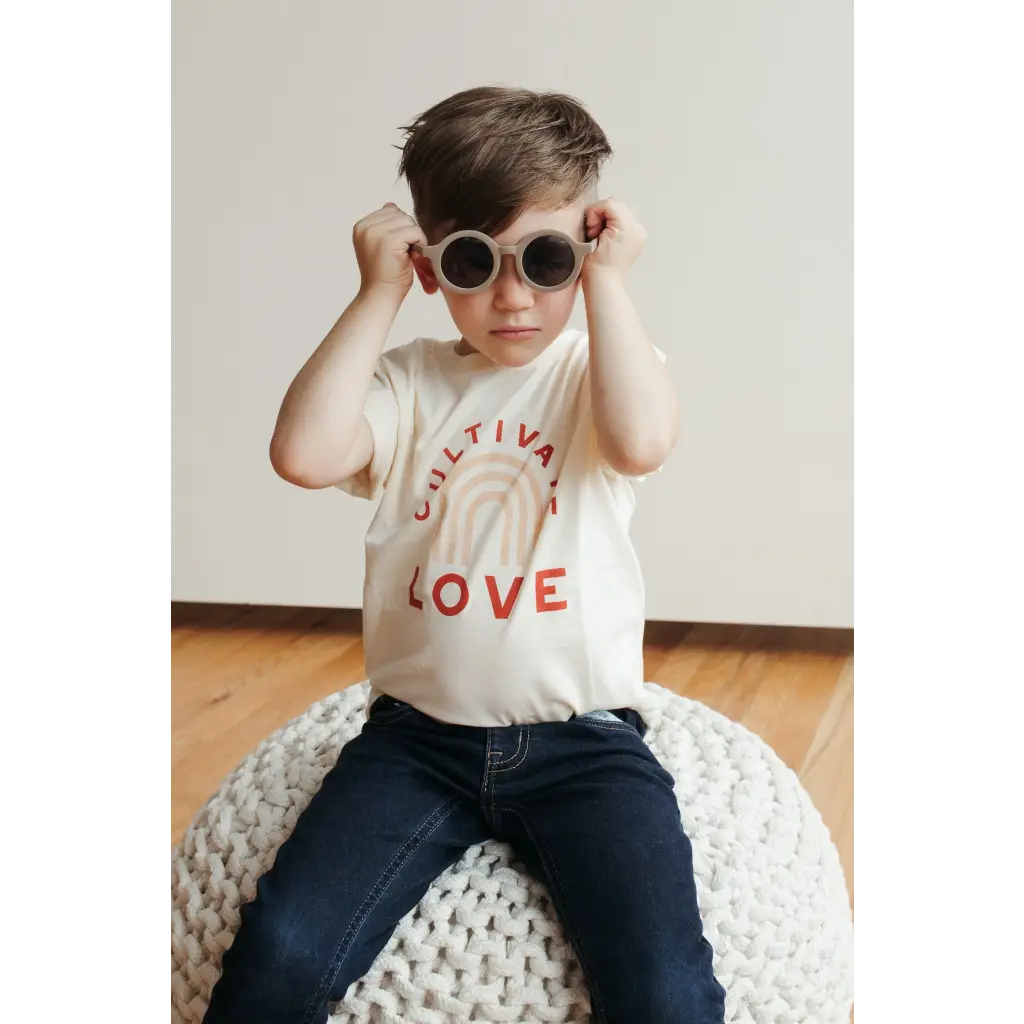 White Cultivate Love Organic Cotton T-shirt for Kids styled with jeans and round sunglasses