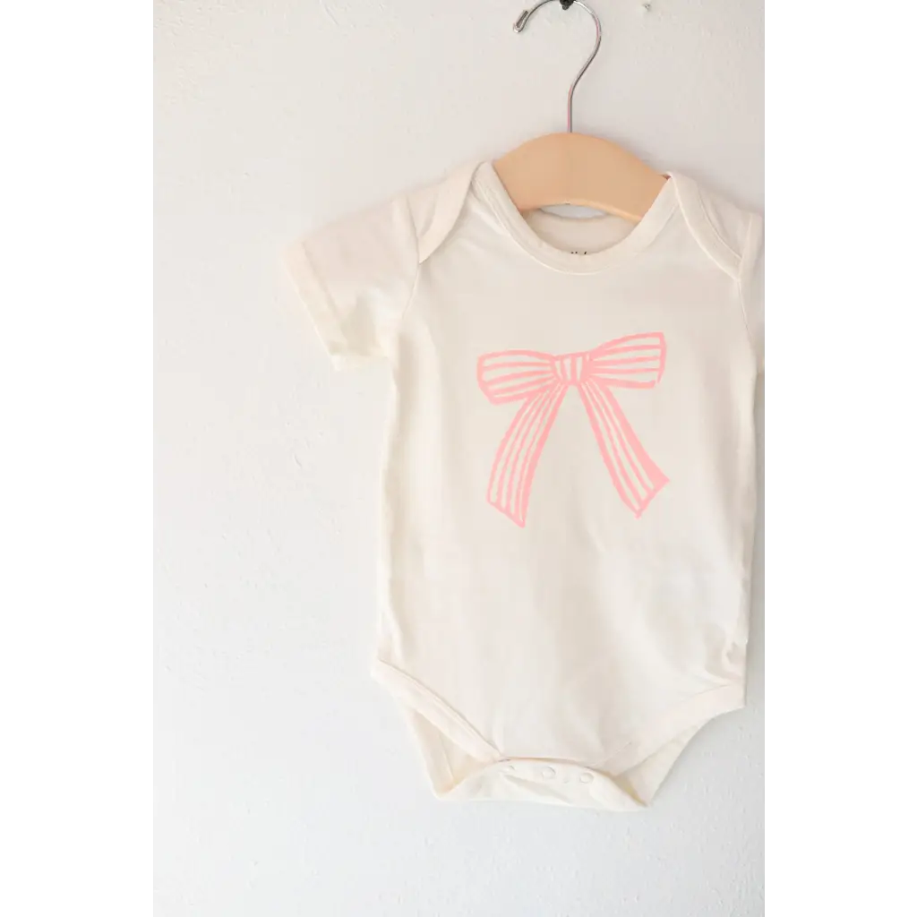 Infant bodysuit in organic cotton with a cute pink bow and polished prints design