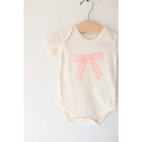 Infant bodysuit in organic cotton with a cute pink bow and polished prints design