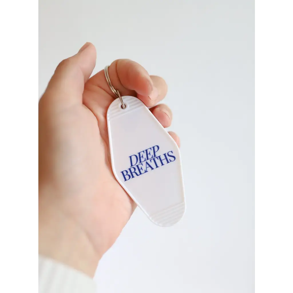 White tag with DEEP BREATHS in blue on the Deep Breaths Vintage Hotel Keychain