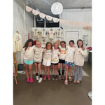 Group of happy girls at craft bar party with matching cream shirts, perfect for bar host events
