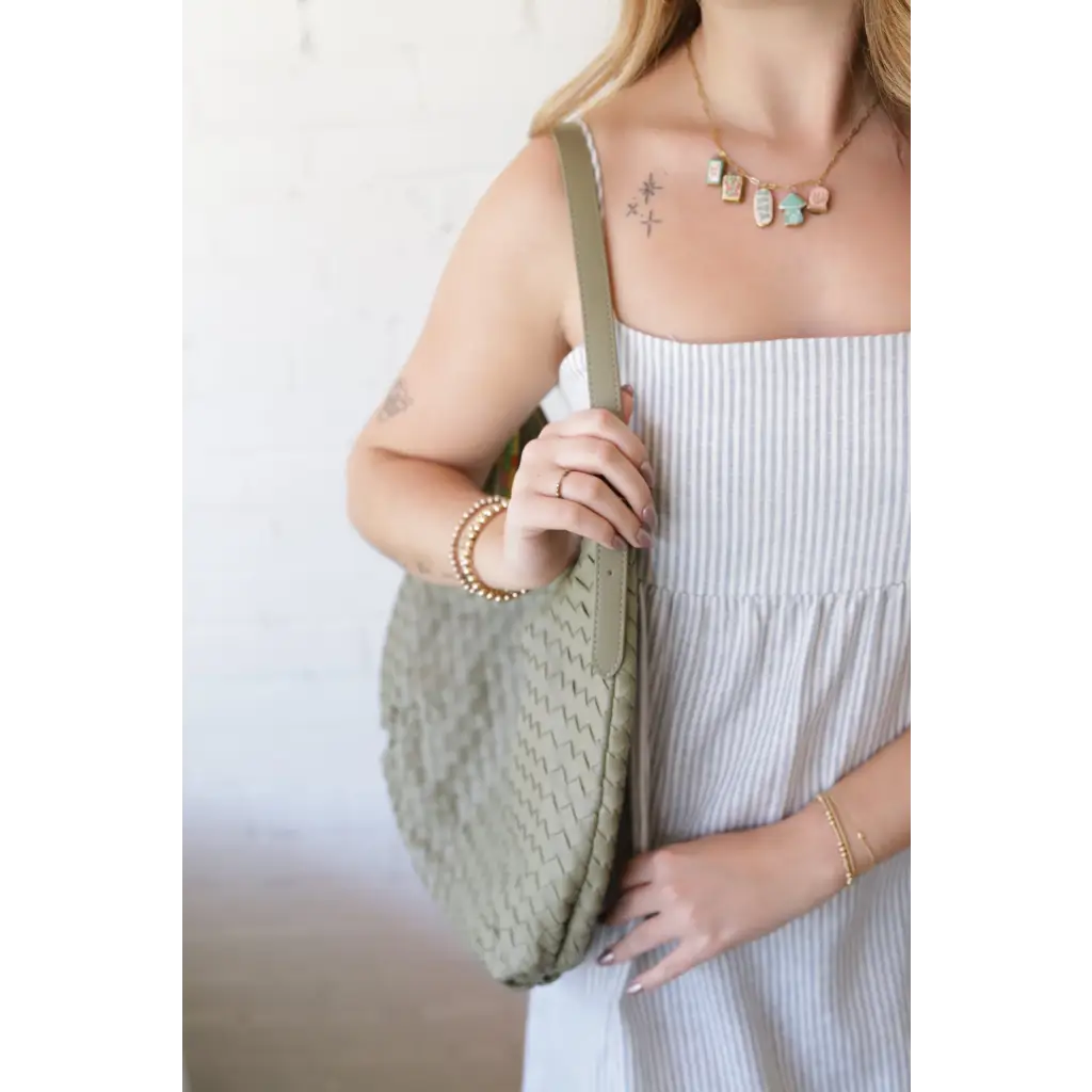 Woman in striped dress holding Diana Woven Bag XL with vegan leather, two interior pockets