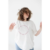 White graphic tee featuring a cozy relaxed fit and polished pink text design