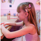 Young girl with long brown hair wearing Dolly Disco Cowgirl Boots with pink hair clips