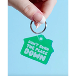 Green keychain tag with text saying DON’T BURN THE PLACE DOWN, perfect for spare keys and curling irons