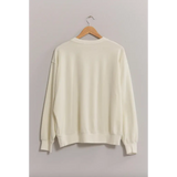 Cream-colored Drew Crew Neck Sweatshirt with drop shoulders on a wooden hanger