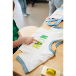 White t-shirt with blue trim and green NOAH lettering for Edwardsville Craft Bar fans