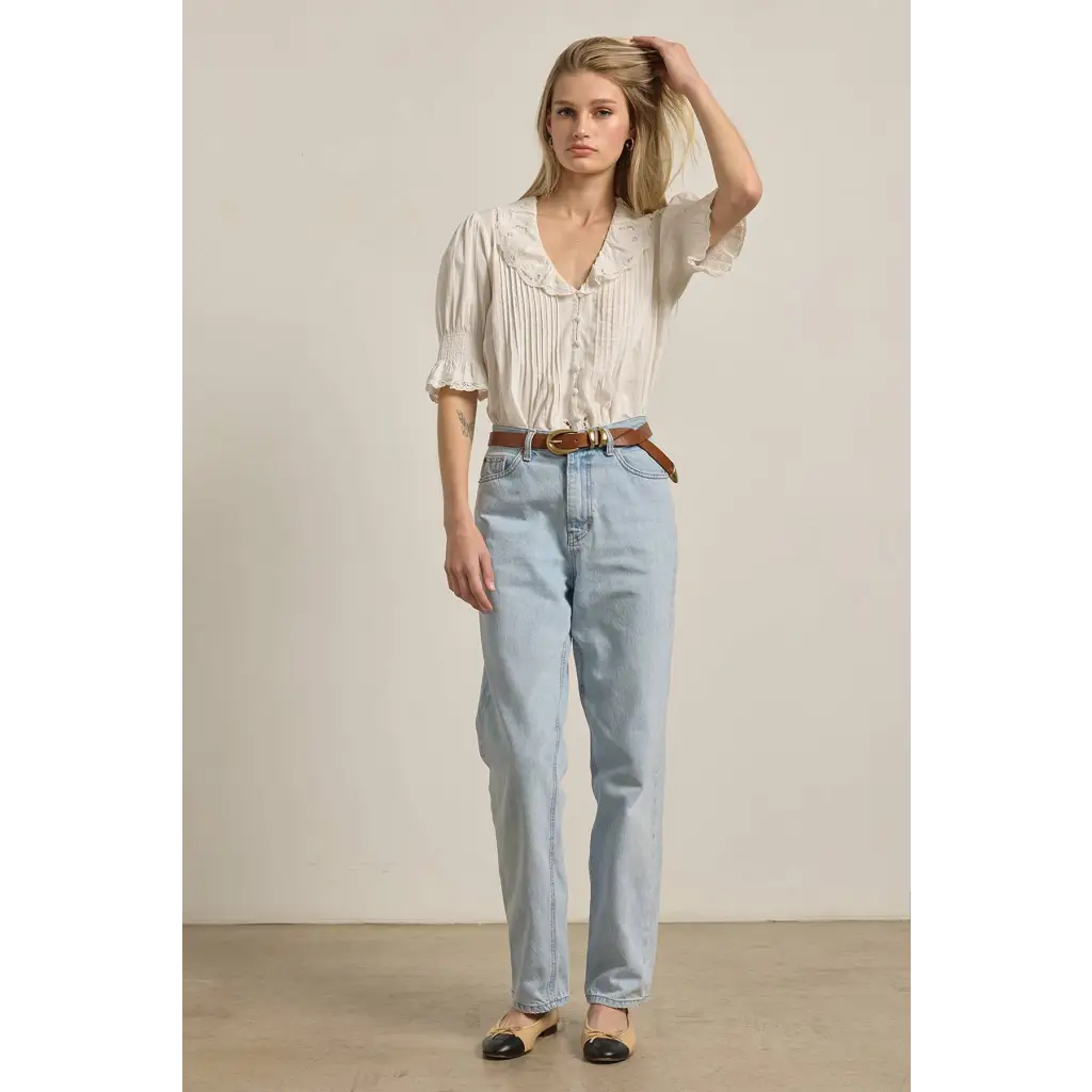 Stylish womens clothes: light-wash straight-leg jeans with belt on woven fabric blouse