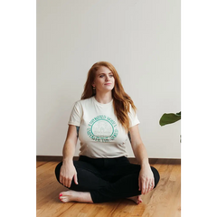 Person in a white Empowered Women Empower the World T-shirt by Polished Prints on wood floor