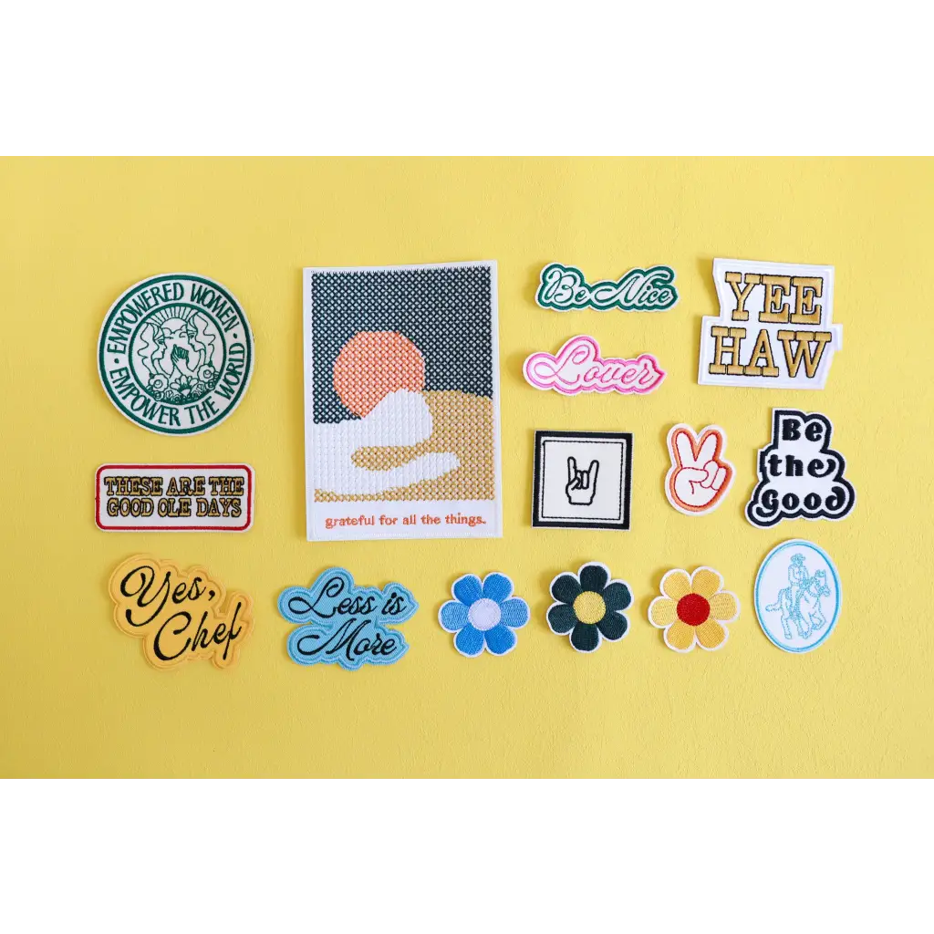 Colorful collection of empowered women iron-on patches on a bright yellow surface