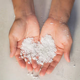 White flake salt in hands from Eucalyptus Bath Soak jar