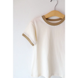 White Everyday Ringer Tee with tan trim hanging on a wooden hanger, perfect for casual style