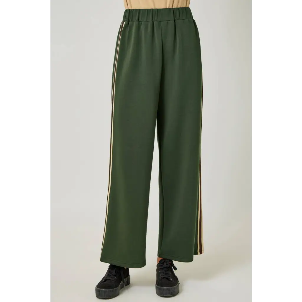 Olive green tracksuit pants with gold stripes and elastic waistband, perfect for stylish womens clothes