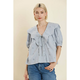 Women’s light blue eyelet blouse with ruffled collar and front tie, perfect stylish womens clothes