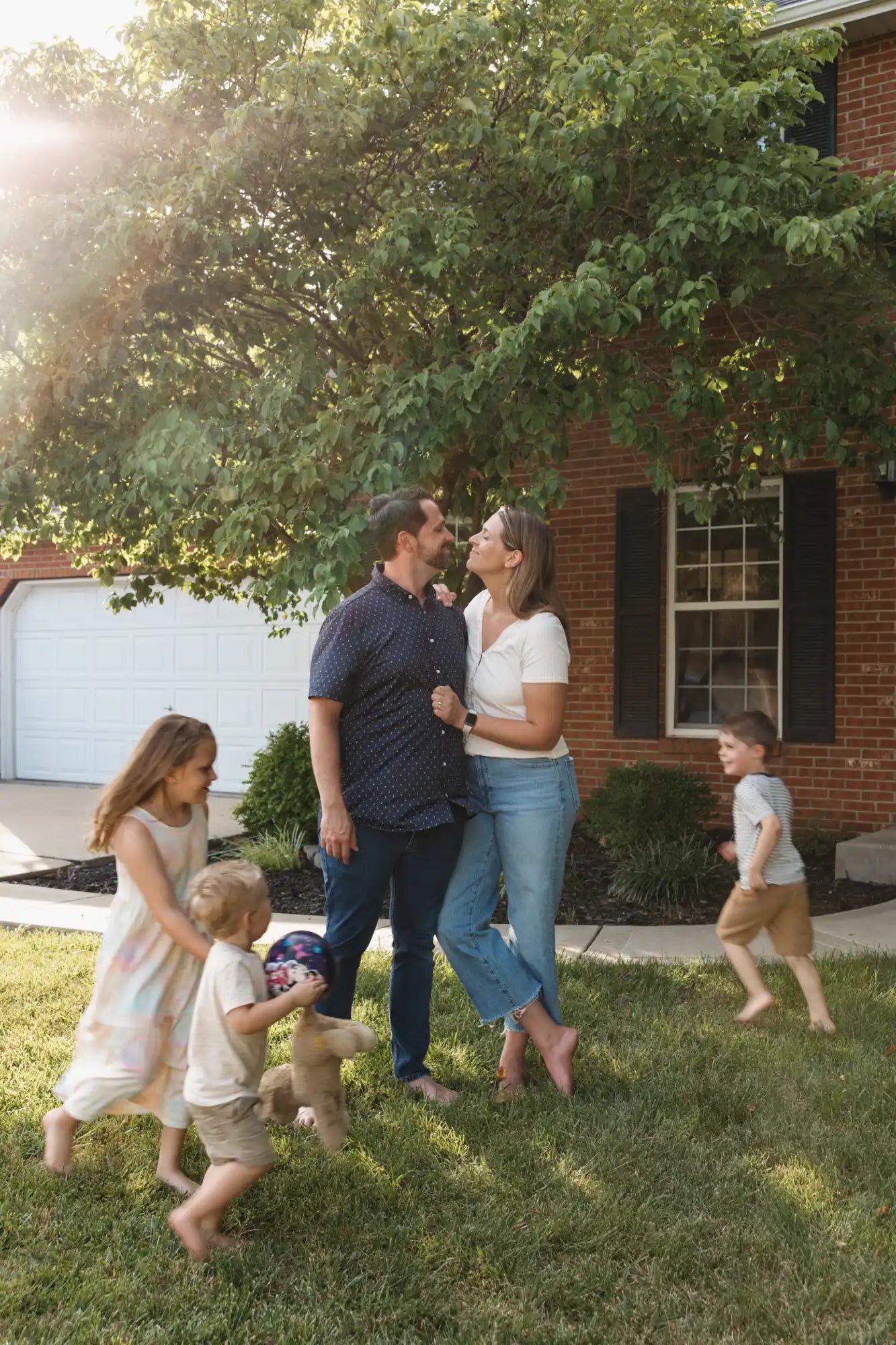 A family enjoying a playful moment together in their front yard.