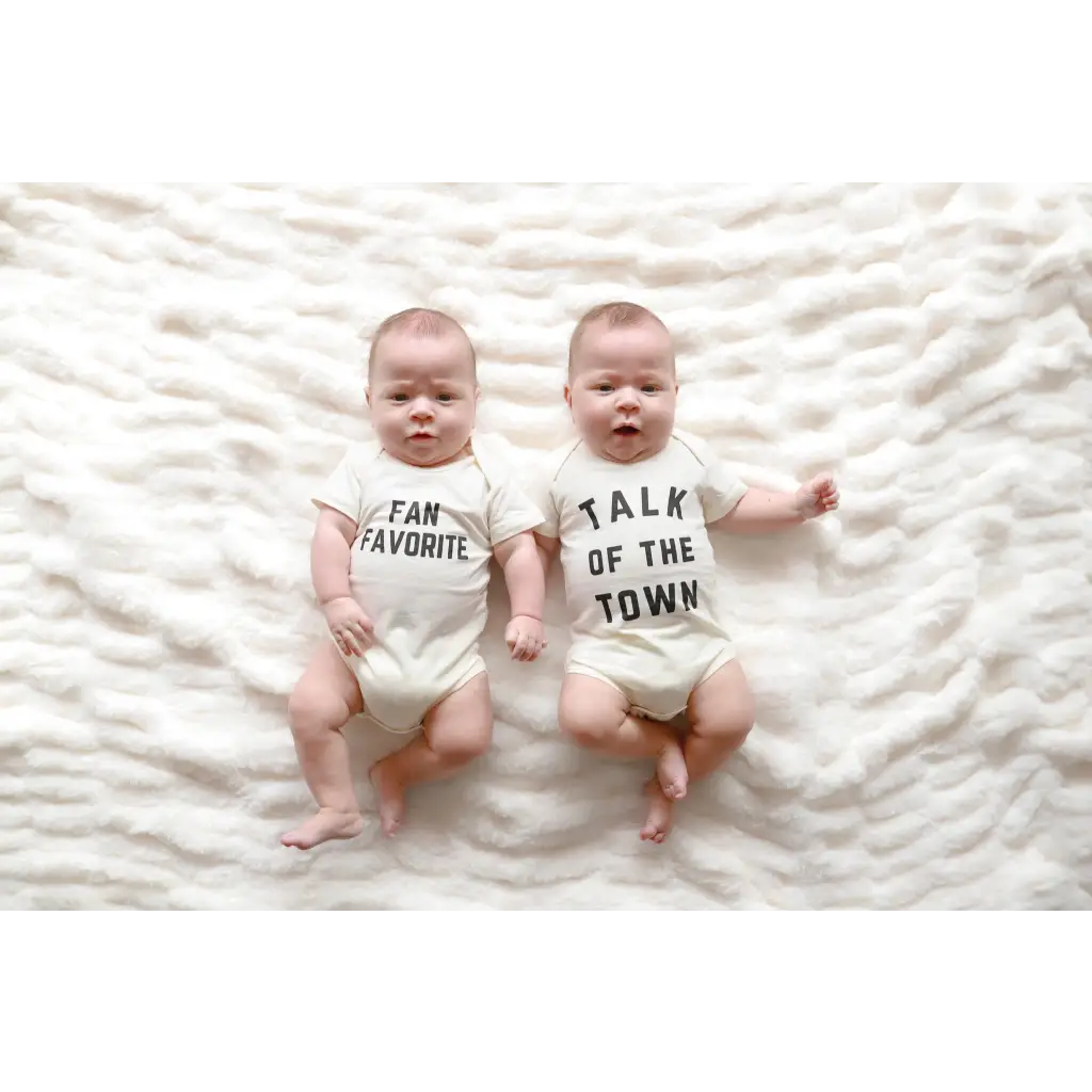 Twin babies in Fan Favorite Baby Onesies featuring cute text for newborns and twins