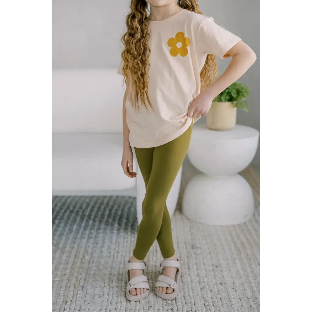 Long wavy blonde hair in a pink tee and Good Vibes flexible lightweight olive green leggings