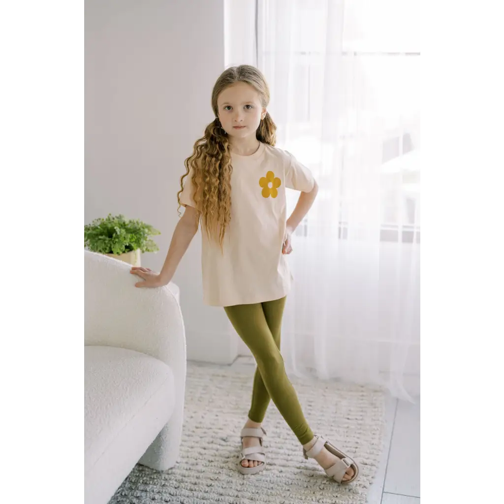 Child in cream top and olive green leggings, rocking Good Vibes Flexible Lightweight Leggings